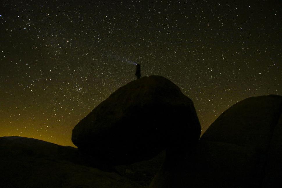 Free Image of Person Standing on Rock Under Night Sky 