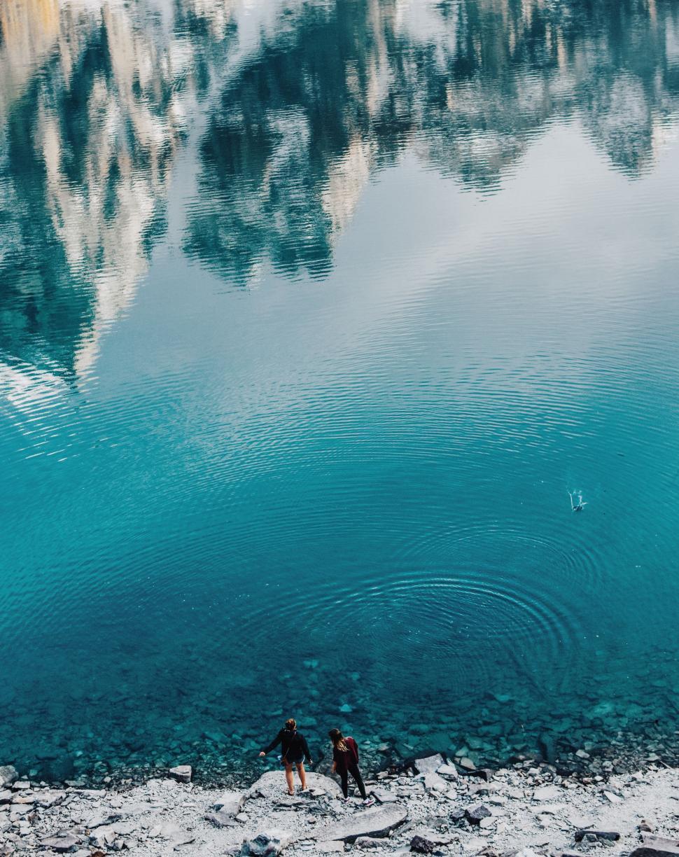 Free Image of People Standing Next to a Body of Water 