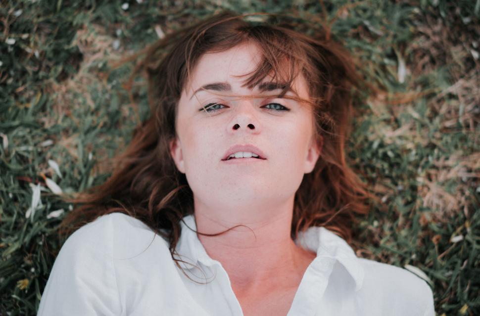 Free Image of Woman Laying in Grass With Eyes Closed 