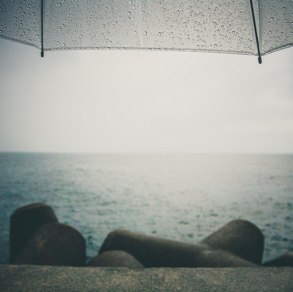 Free Image of Person Laying on Beach Under Umbrella 