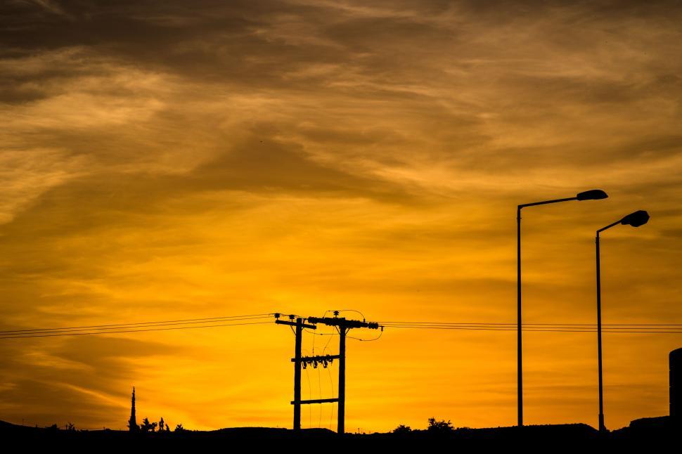 Free Image of Sun Setting Over City With Power Lines 