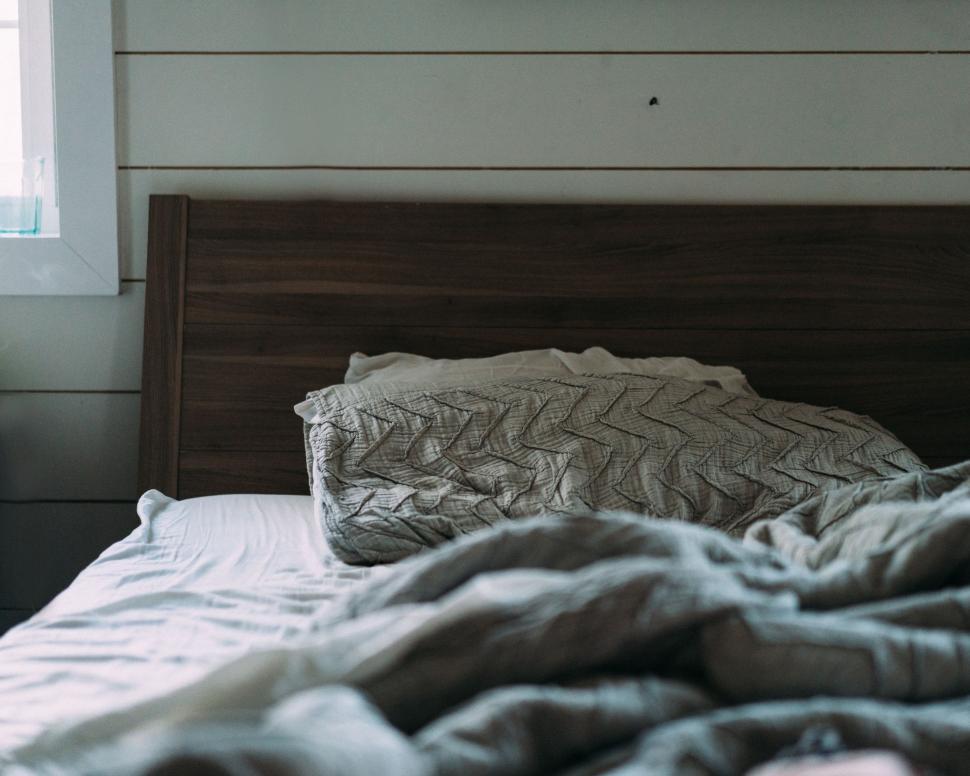 Free Image of Bed With Wooden Headboard and Window 