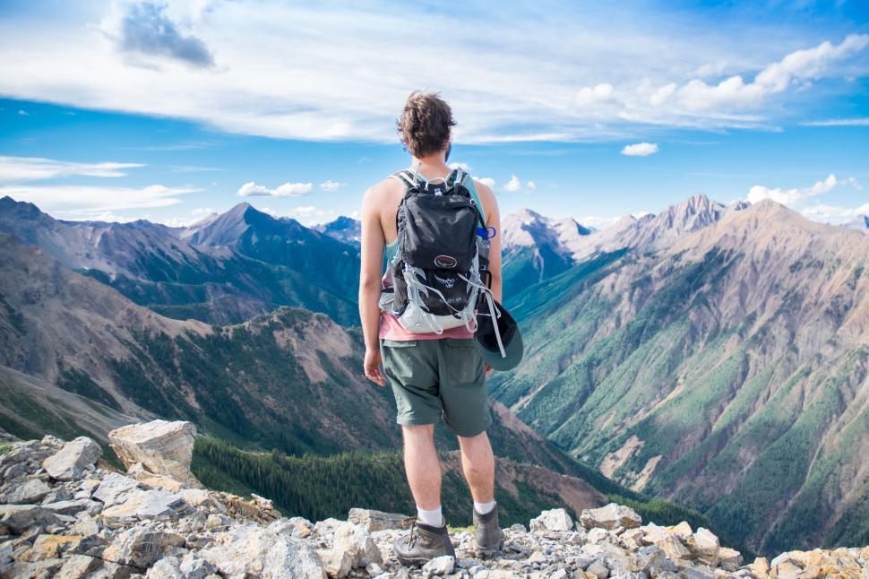 Free Image of Man Standing on Top of Mountain With Backpack 
