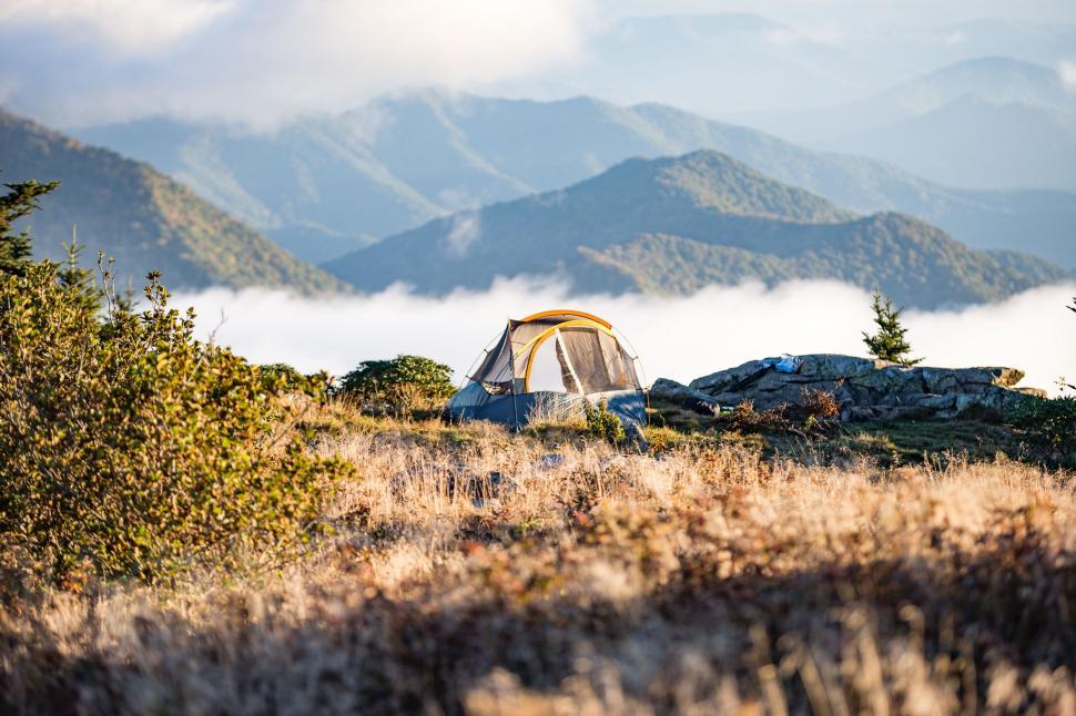 Free Image of Tent Pitched in Field With Mountains 