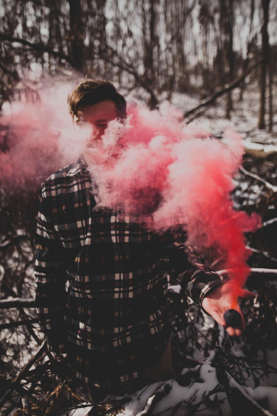 Free Image of Man Standing in Snow With Pink Smoke 