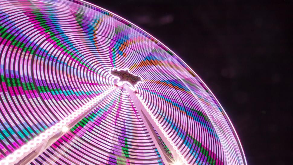 Free Image of Vibrant Ferris Wheel Spinning in the Dark 