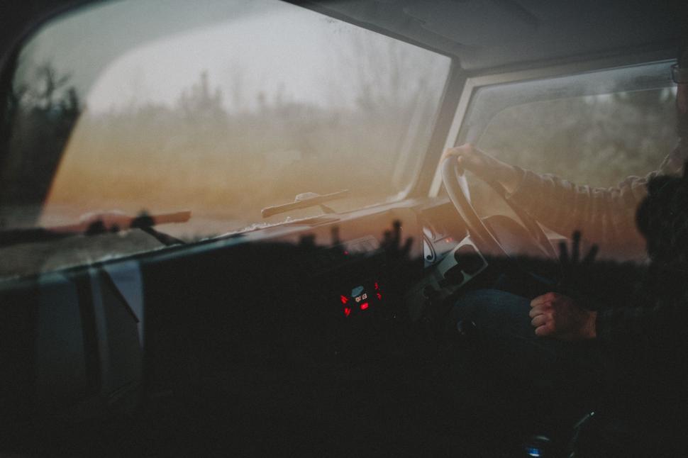 Free Image of Person Sitting in Vehicle With Hand on Steering Wheel 