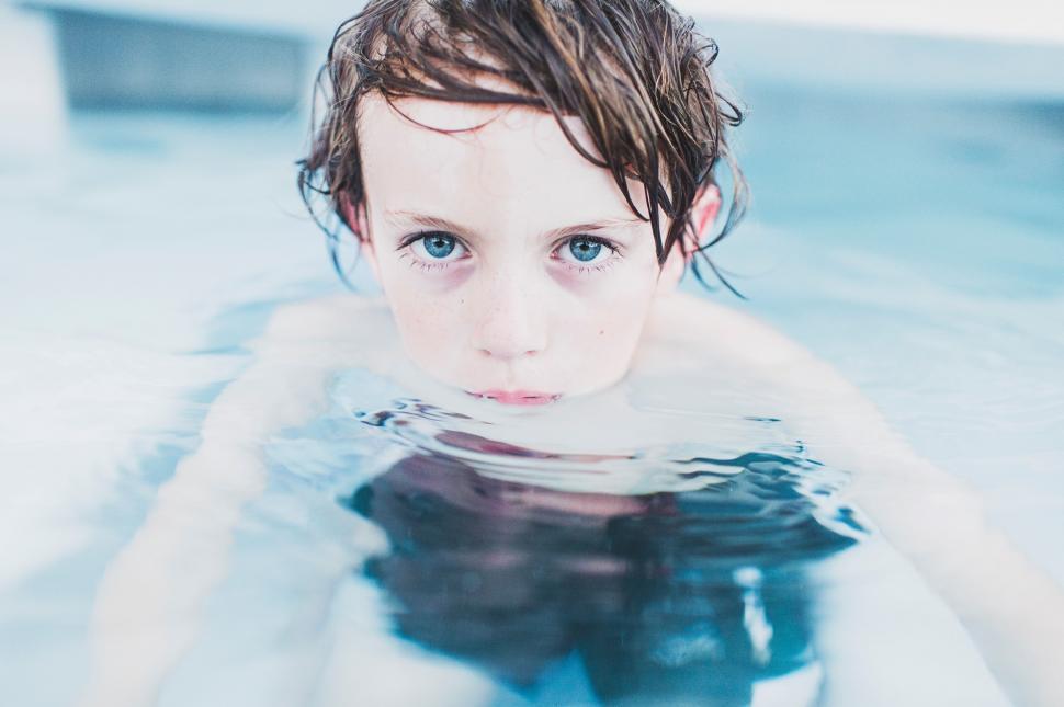 Free Image of Young Boy With Blue Eyes Swimming in Pool 