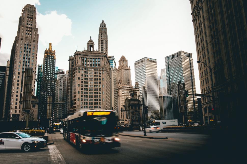 Free Image of Bus Driving Down Street Next to Tall Buildings 
