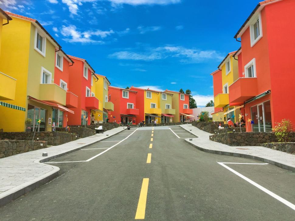 Free Image of Colorful Houses Lining Street Under Blue Sky 