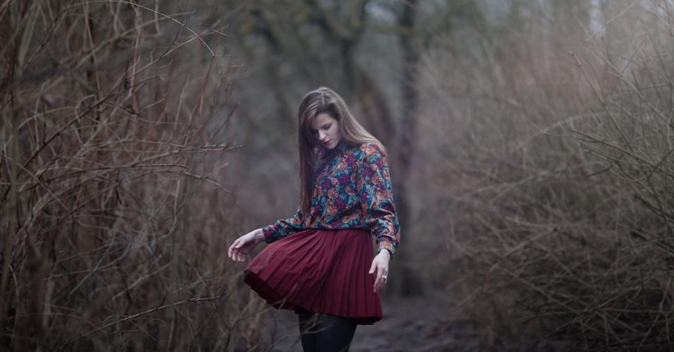 Free Image of Woman Walking in Red Skirt Through Forest 