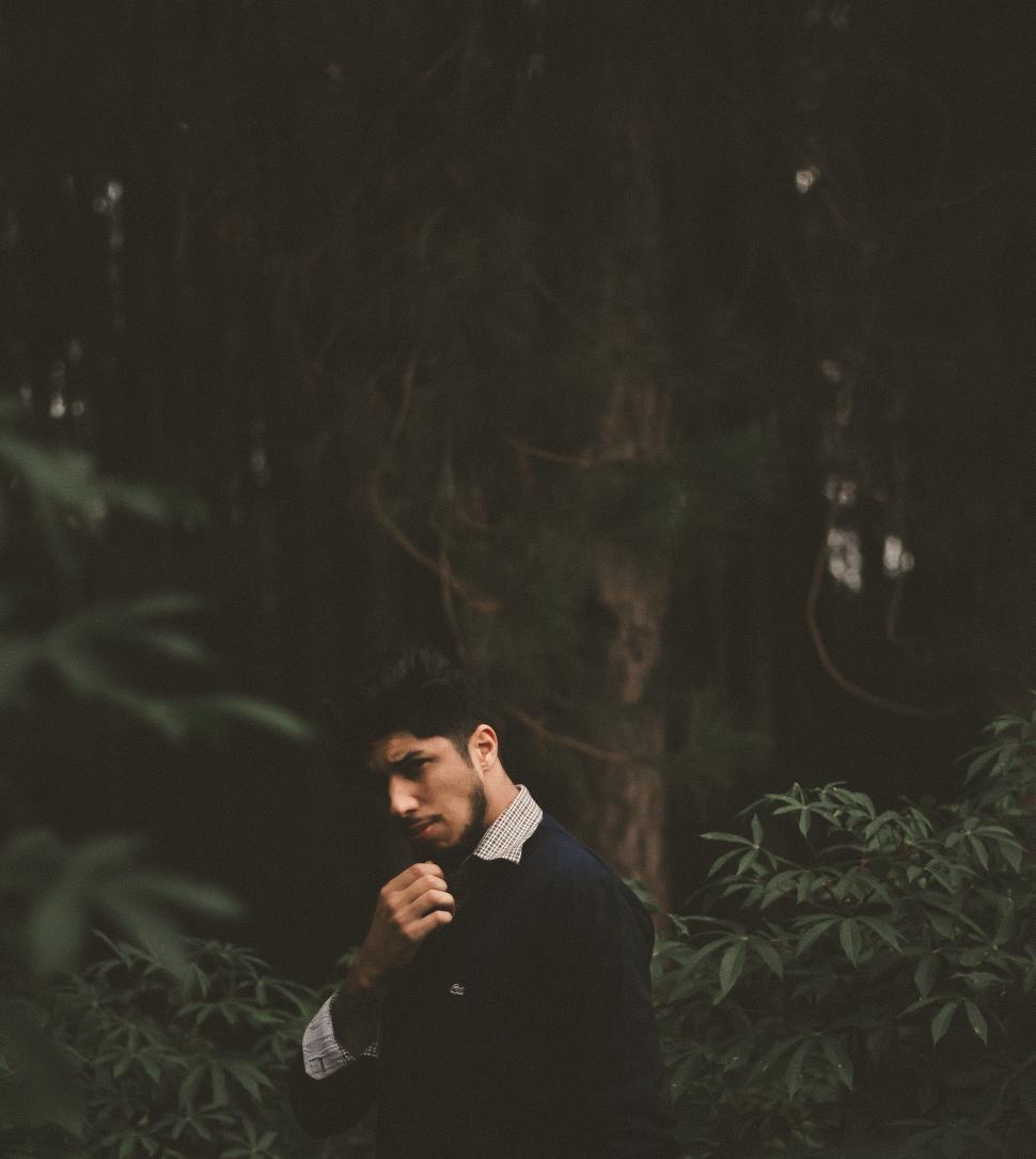 Free Image of Man Standing in Forest Holding Microphone 