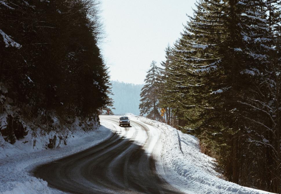 Free Image of Car Driving Down Snow-Covered Road 