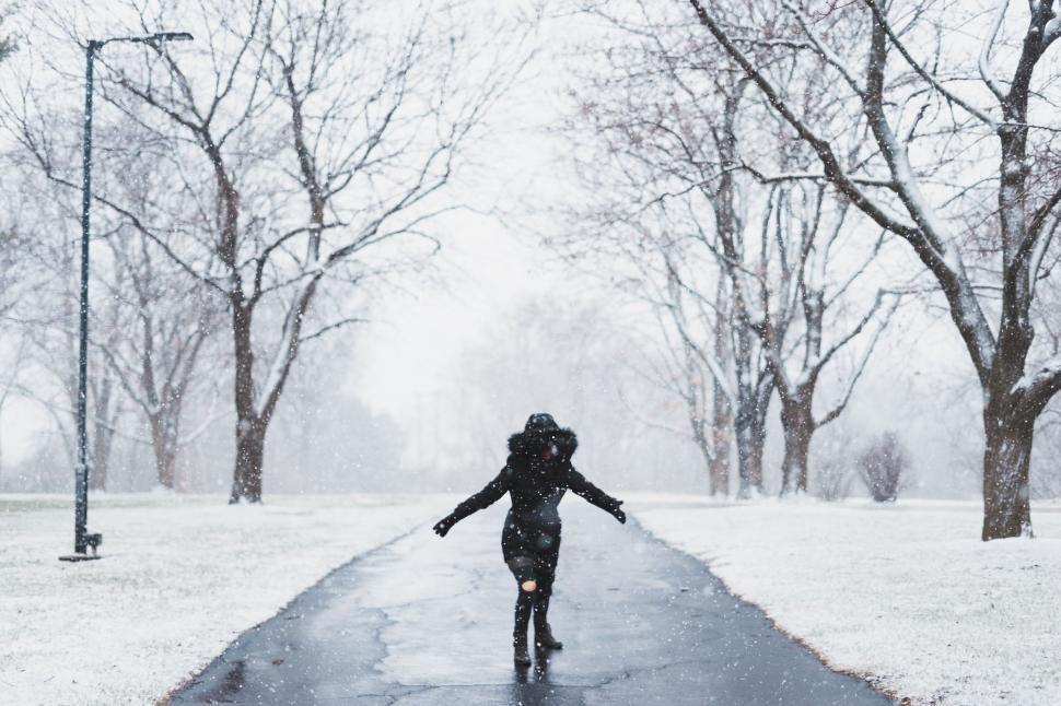 Free Image of Person Walking Down a Sidewalk in Snow 
