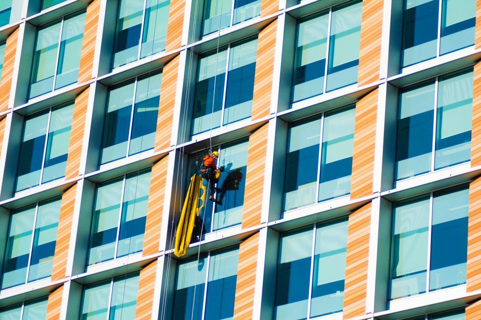 Free Image of Man Working on the Side of a Building 