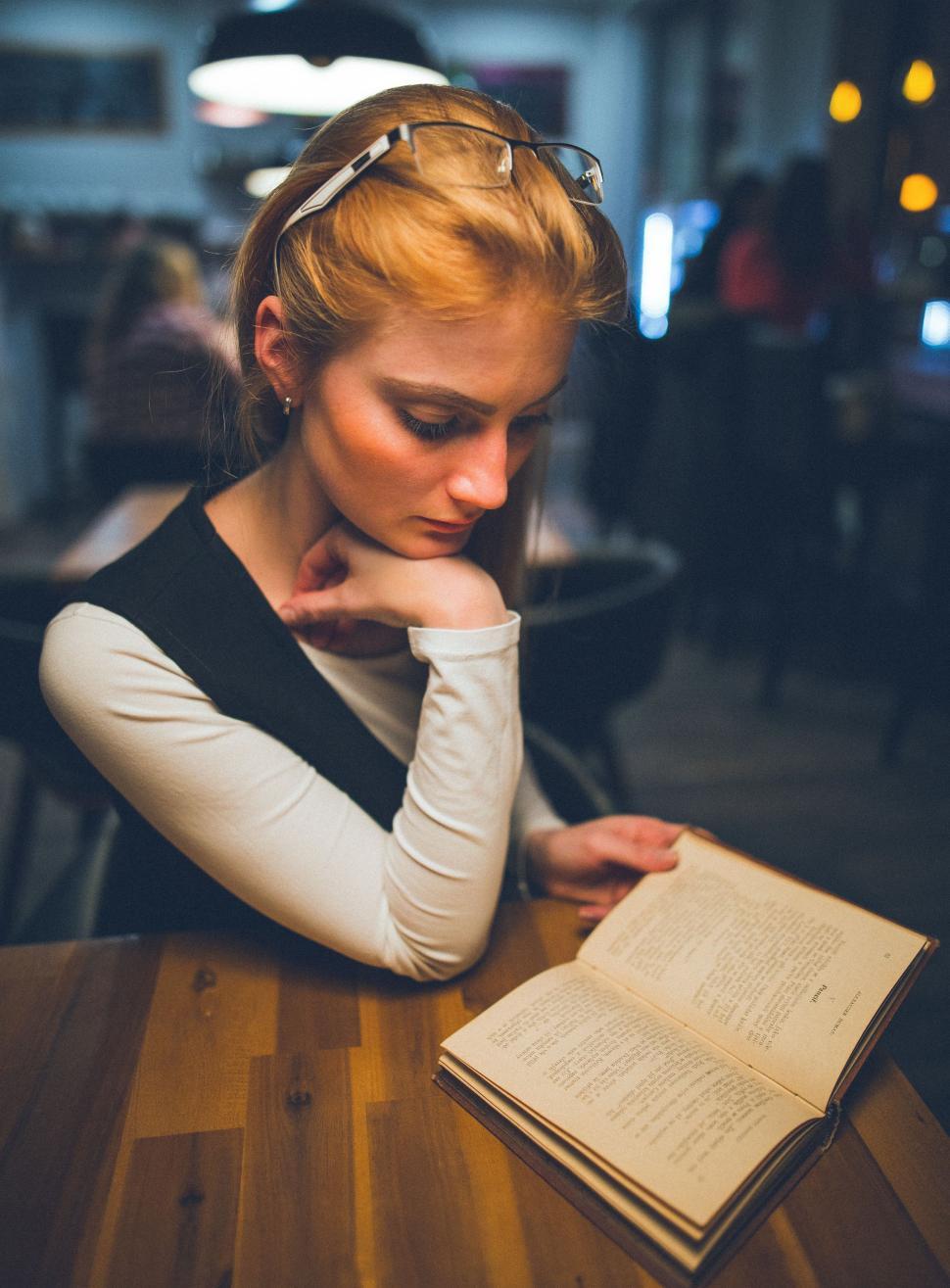 Free Image of Woman Reading Book at Table 