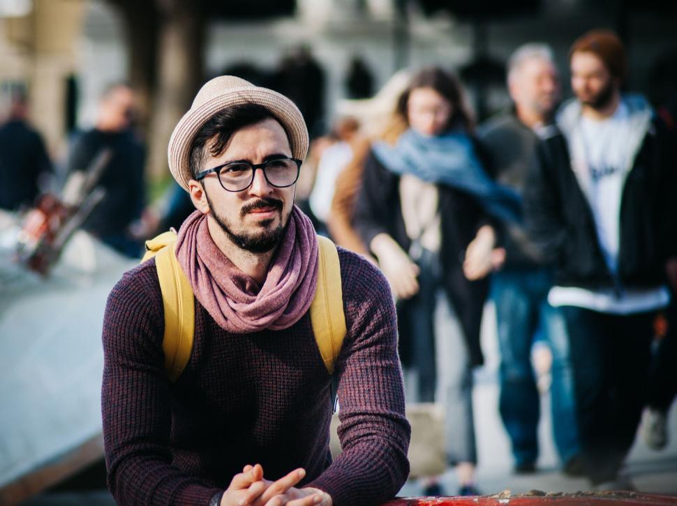Free Image of Man With Hat and Glasses Sitting on Skateboard 