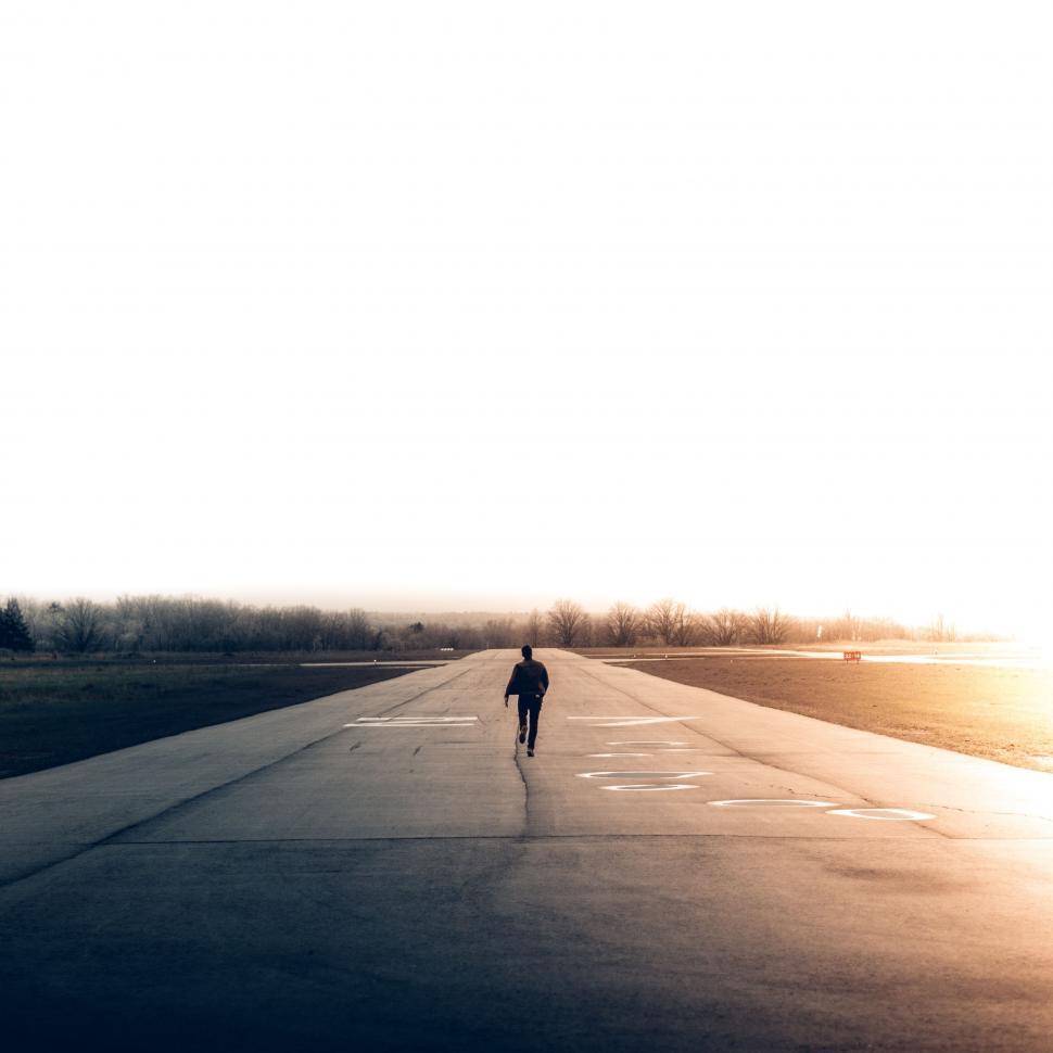 Free Image of Person Walking Down the Middle of a Road 