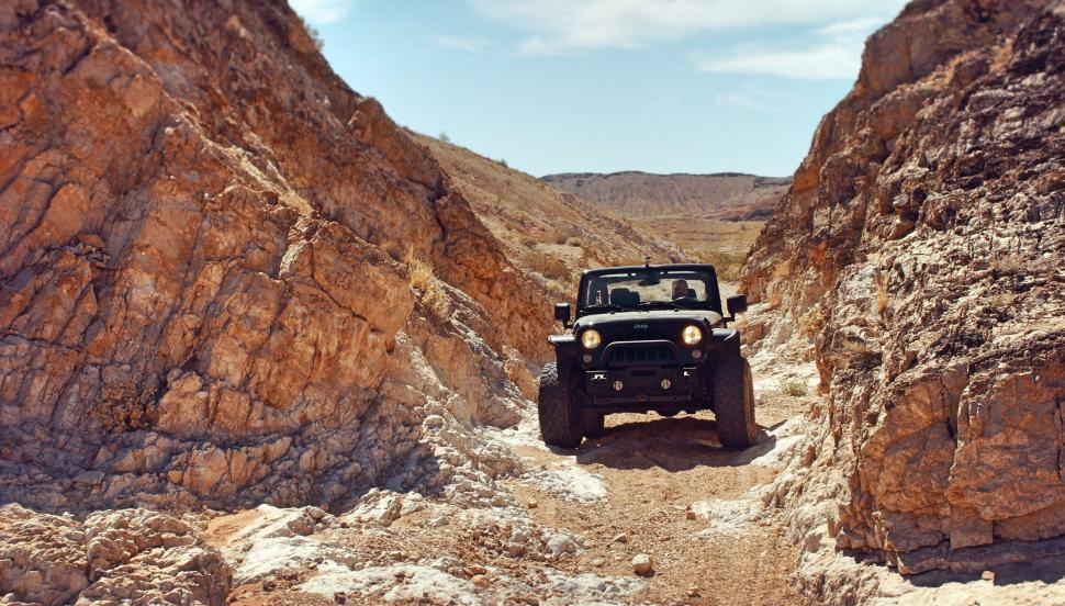 Free Image of Jeep Driving Through Narrow Canyon in the Desert 