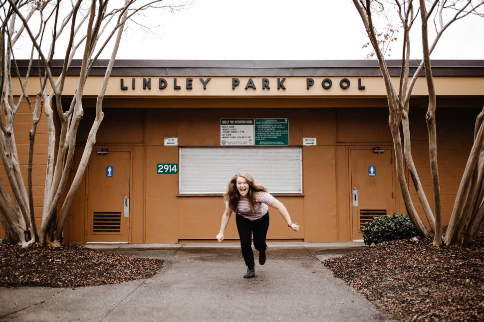 Free Image of Woman Running in Front of Park Pool 