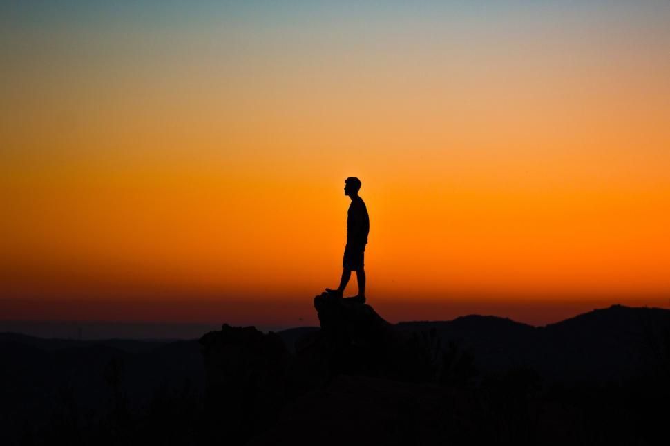 Free Image of Man Standing on Top of Hill at Sunset 