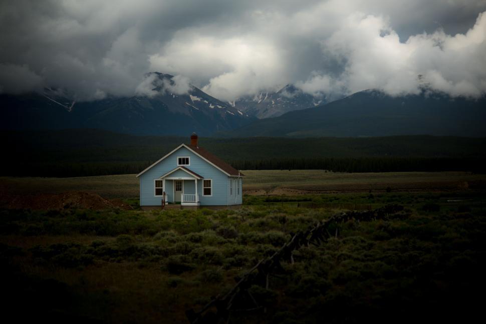 Free Image of House in a Field With Mountains in the Background 
