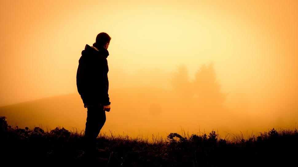 Free Image of Person Standing on Hill With Sun in Background 