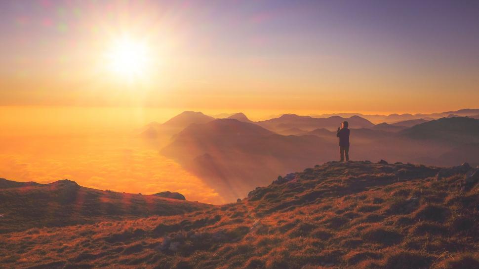 Free Image of Person Standing on Top of Mountain at Sunset 