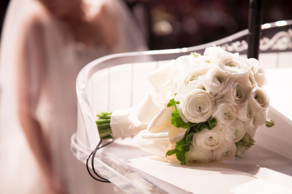 Free Image of Bride Holding Bouquet of White Flowers 