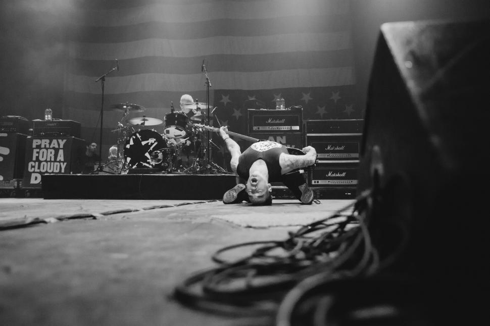 Free Image of Man Laying on Ground in Front of Stage 