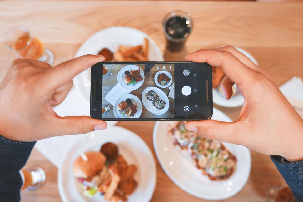 Free Image of Person Taking Picture of Food on Table 