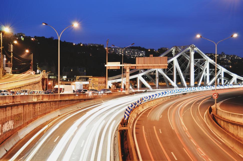 Free Image of Night Time View of Highway With Bridge in Background 