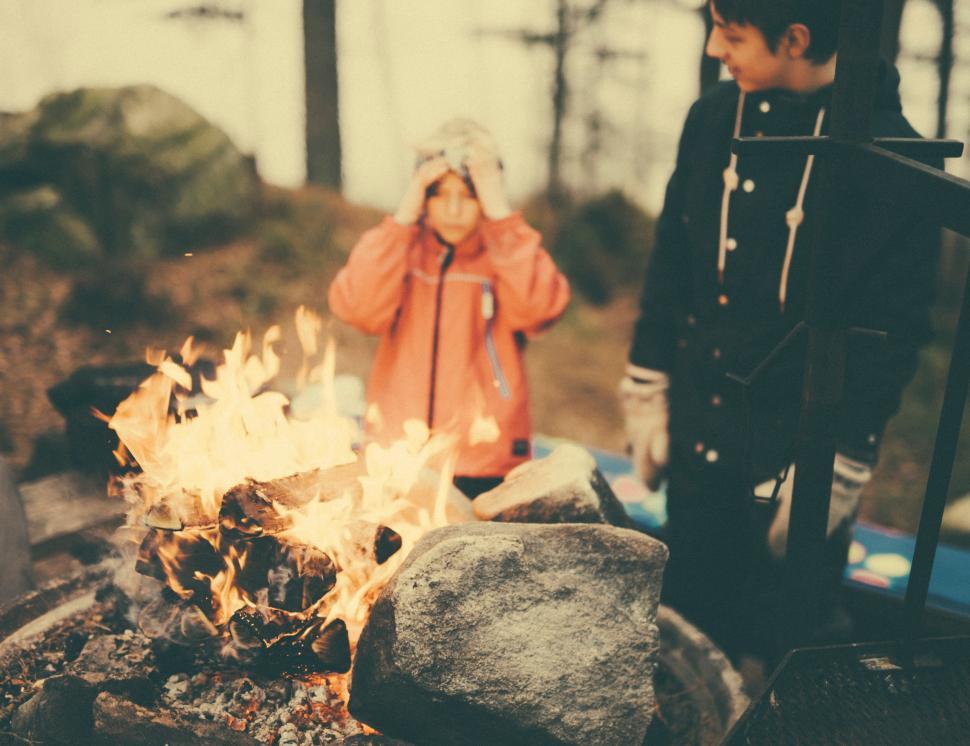Free Image of Boy and Girl Standing Next to Campfire 