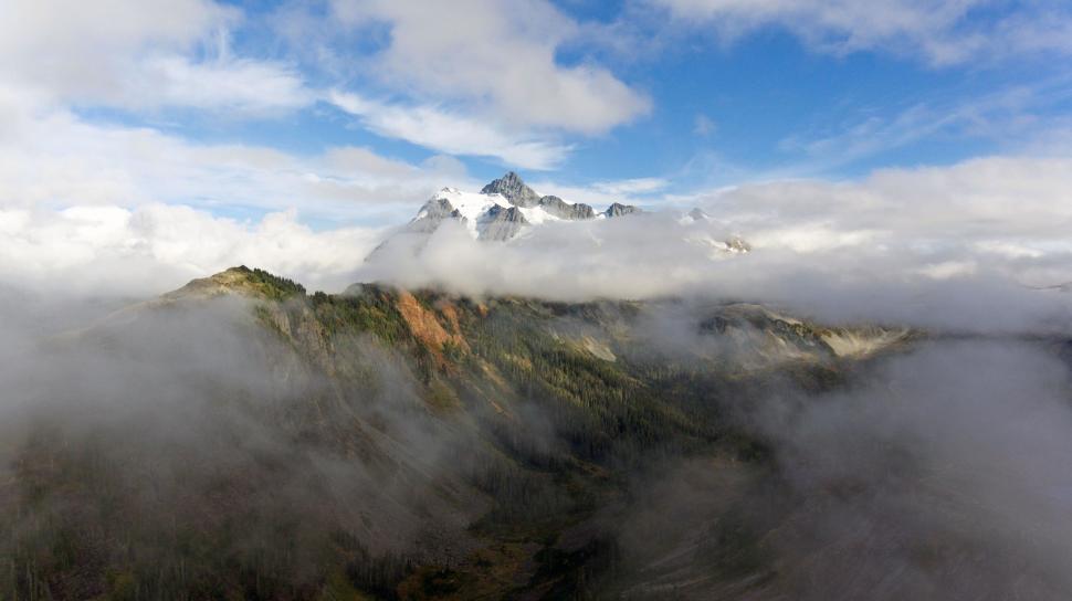 Free Image of Clouds Blanketing a Majestic Mountain 