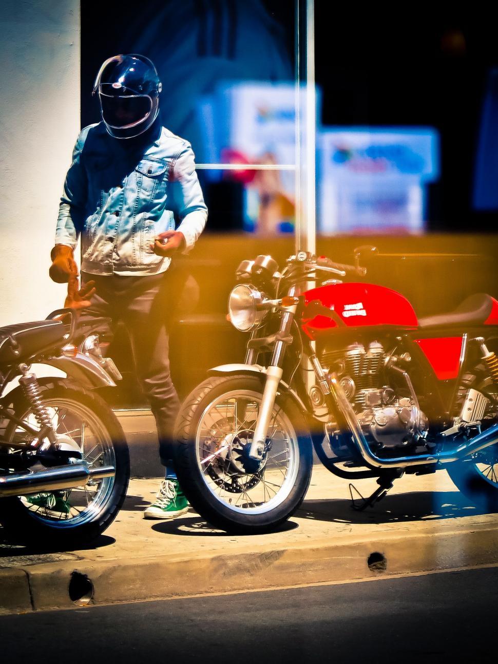 Free Image of Man Sitting on Motorcycle Next to Another Bike 