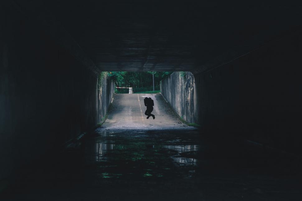 Free Image of Person Walking Through Dark Tunnel 