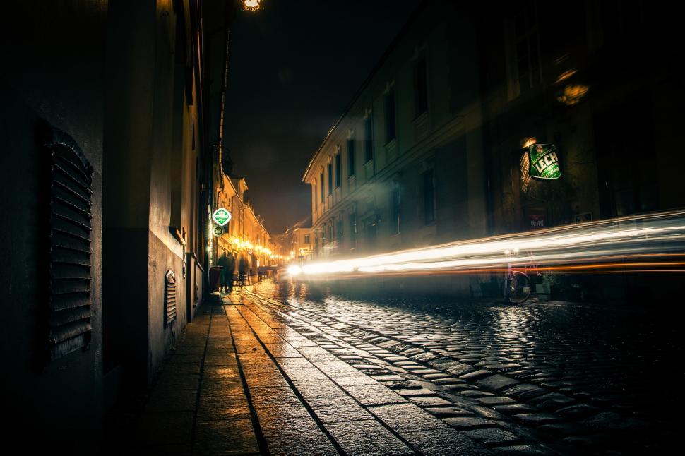Free Image of City Street at Night With Passing Car 