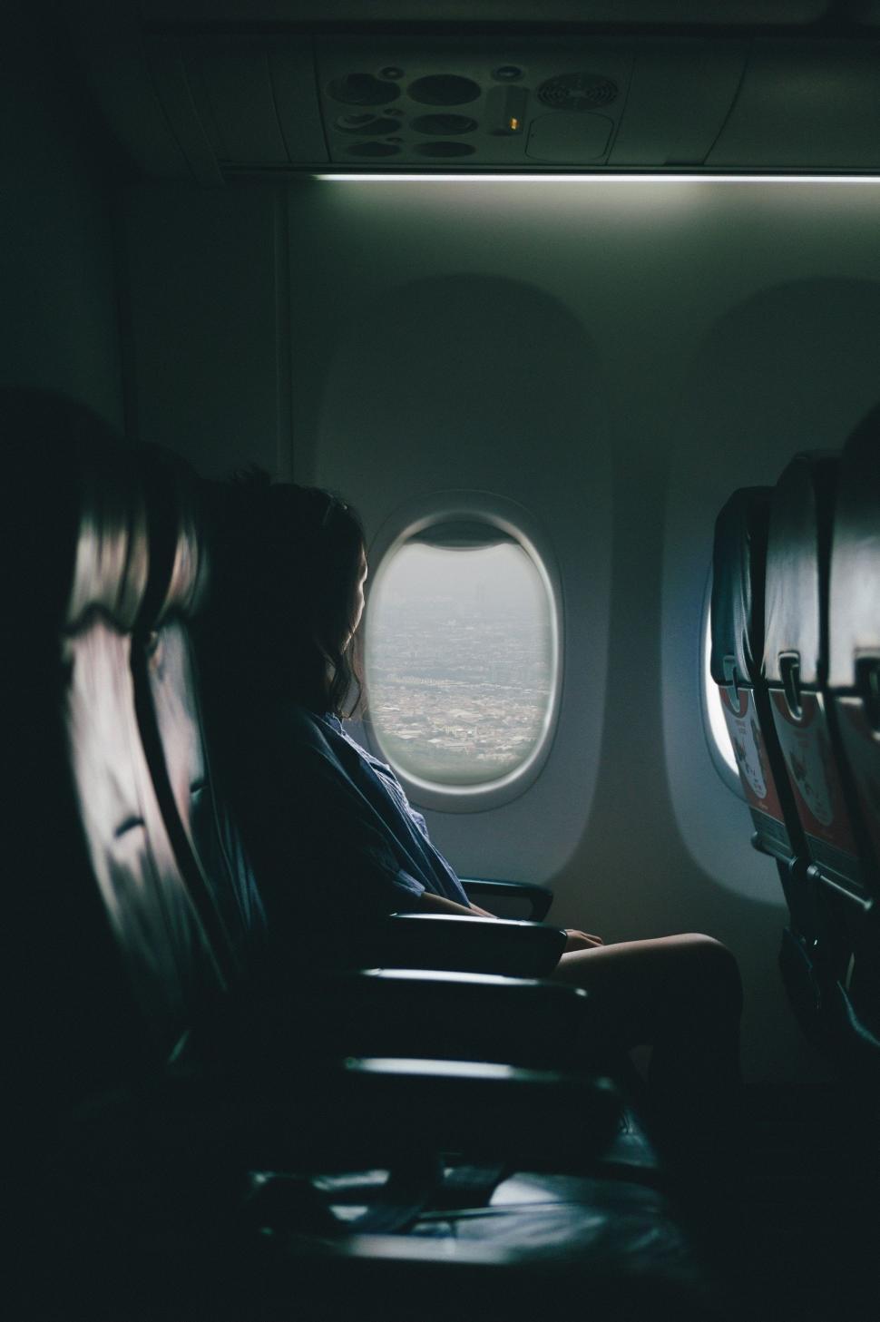 Free Image of Person Sitting in Airplane Looking Out Window 