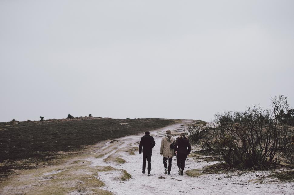 Free Image of Group of People Walking Down a Dirt Road 