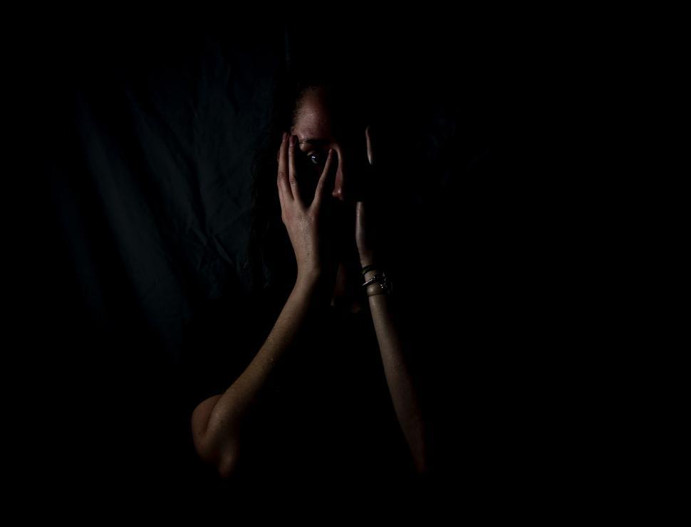Free Image of Woman Covering Face in Darkness 
