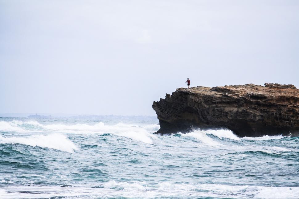 Free Image of Person Standing on Rock in Middle of Ocean 
