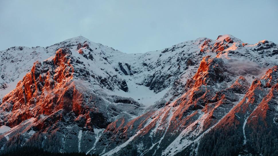 Free Image of Snow-Covered Mountain Bathed in Red Light 