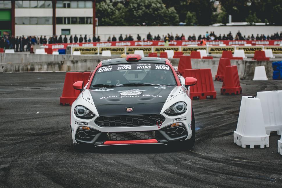 Free Image of Car Driving on Race Track With Red and White Barriers 