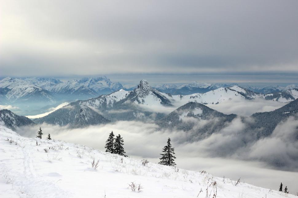 Free Image of Snow Covered Mountain With Trees and Clouds 