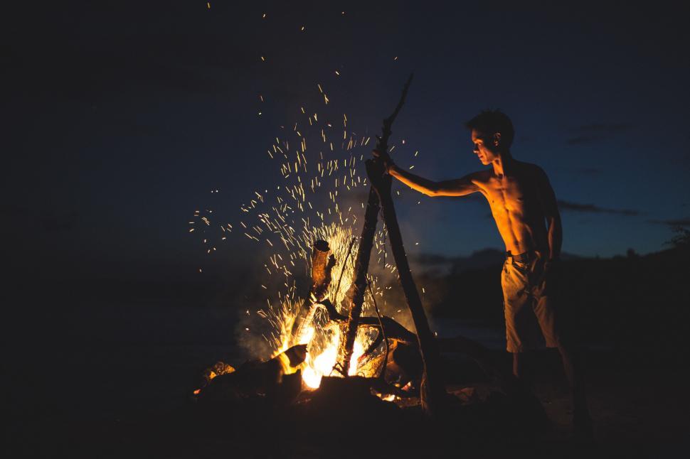 Free Image of Man Standing Next to Fire With Sparks 