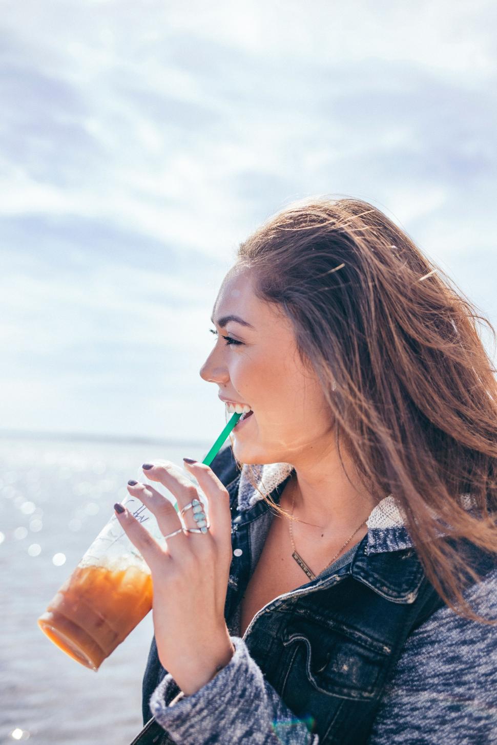 Free Image of Woman Drinking Beverage by Water 