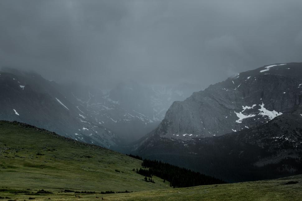 Free Image of Majestic Mountain Range Blanketed in Snow and Clouds 
