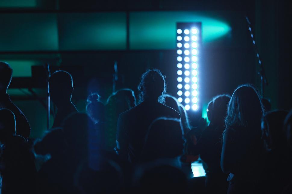 Free Image of Group of People Standing in Front of a Green Light 