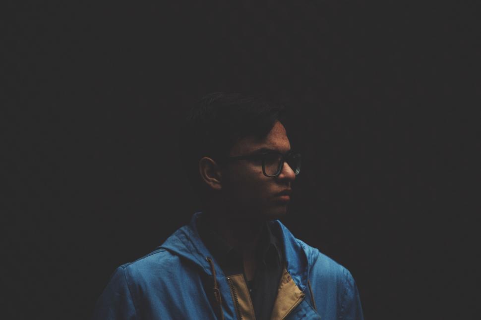 Free Image of Man Standing in Dark With Blue Jacket On 