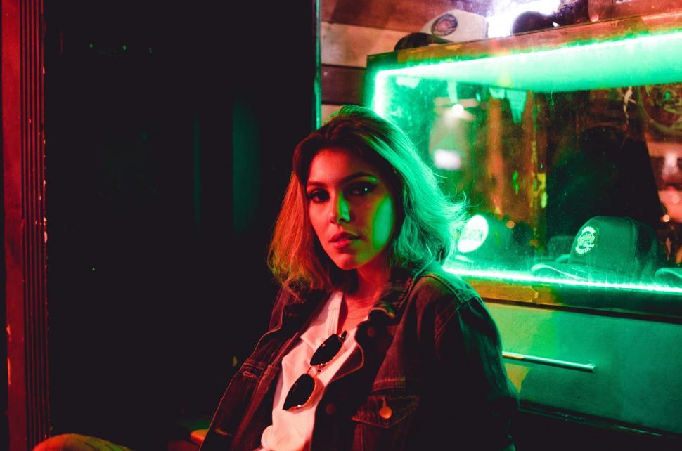 Free Image of Woman Sitting in Front of Green Light 